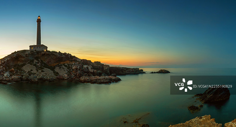 日落时分，山丘上的高耸灯塔图片素材