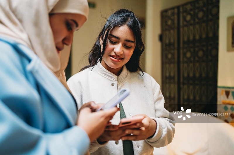年轻的穆斯林女性使用智能手机进行交流图片素材