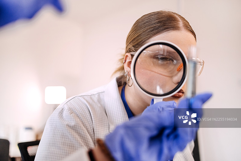 年轻的科学家们在实验室里一起使用放大镜进行研究图片素材