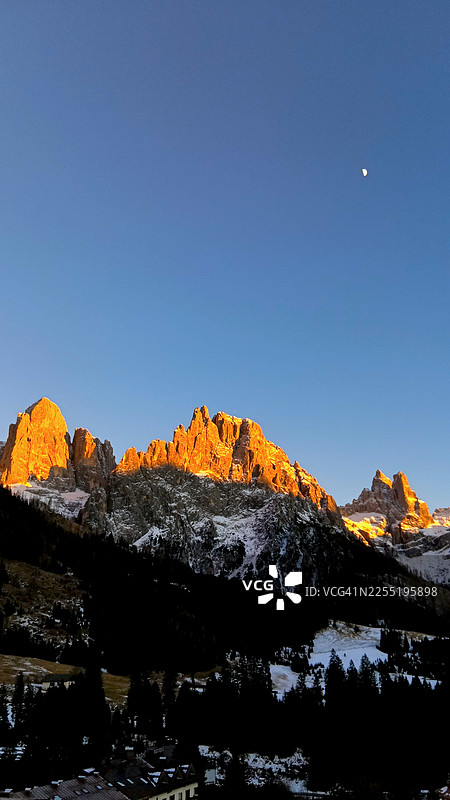 意大利多洛米蒂阿尔卑斯山圣马蒂诺迪卡斯特罗扎拍摄的日落时分圣马蒂诺山脉全景，伴有满月图片素材