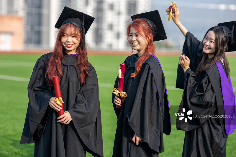 成功时刻 - 年轻的女大学生在户外毕业图片素材