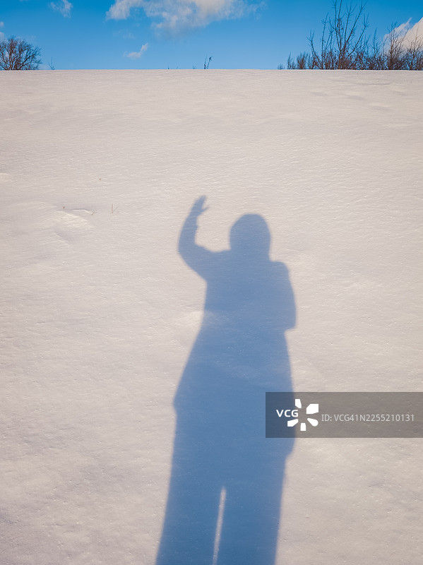 在洁白的新雪上挥手的剪影图片素材