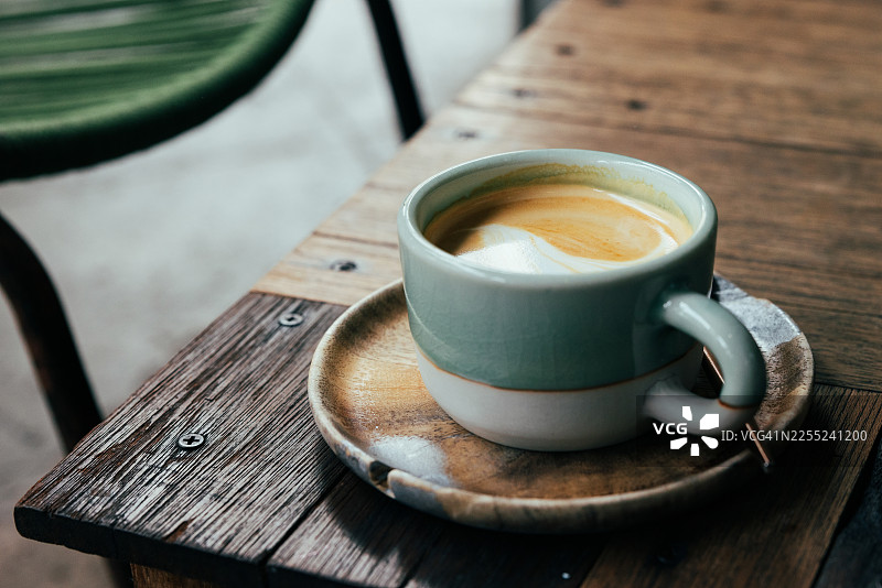 咖啡店桌上的一杯拿铁，上面有咖啡拉花。图片素材