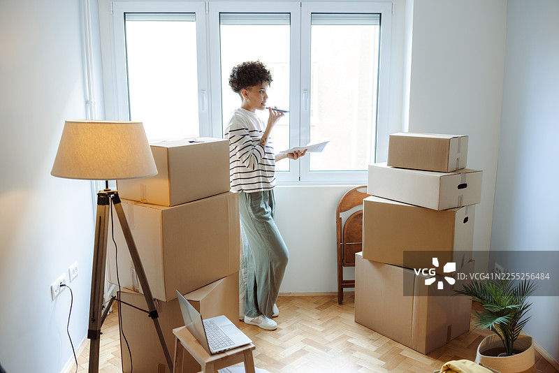 短发年轻女子在拆箱日整理箱子和文件图片素材