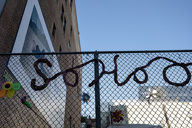 游乐场围栏上的标语宣告我们身处SoHo。图片素材