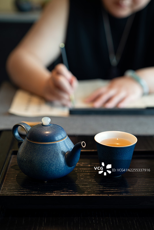 一位优雅的女士正在练习书法。图片素材