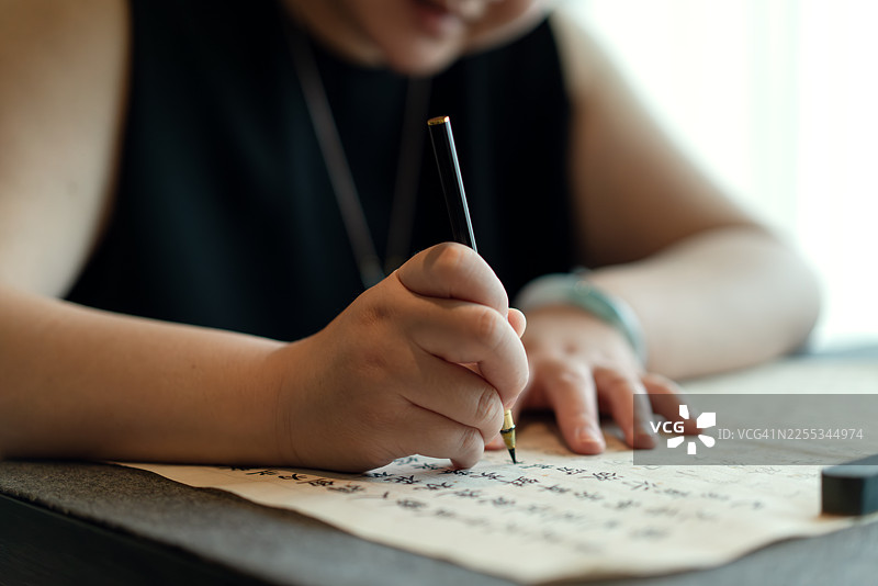 一位优雅的女士正在练习书法。图片素材