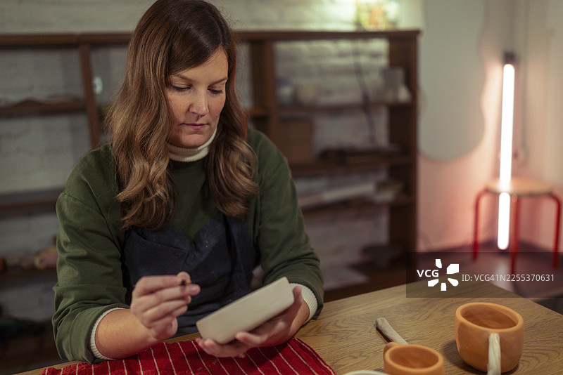女工匠在工作室装饰手工陶瓷图片素材