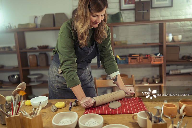 女陶艺家在陶艺工作室塑造陶土图片素材