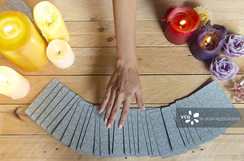 女性手持塔罗牌占卜，烛光氛围图片素材