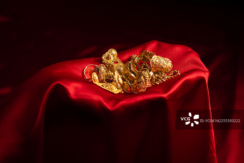红色缎面背景上的优雅金色珠宝系列图片素材
