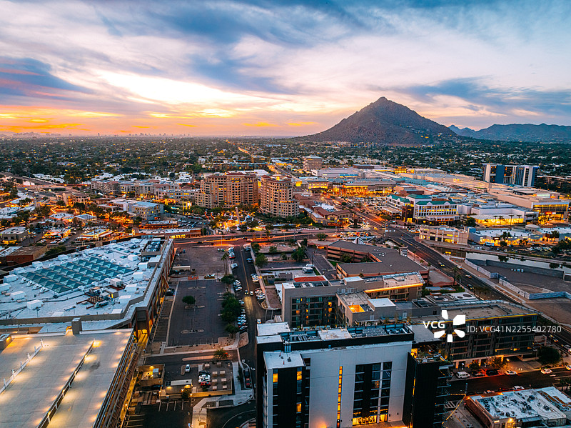 日落时分亚利桑那州斯科茨代尔市中心“老城区”的鸟瞰图，背景为骆驼背山图片素材