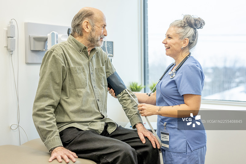 护士在诊所为老年患者测量血压，温馨的医疗检查时刻图片素材