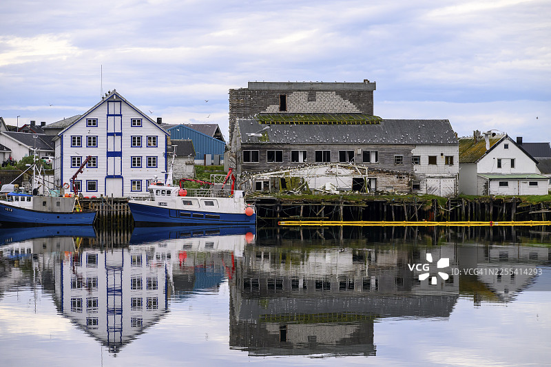 挪威芬马克郡瓦朗厄尔半岛北部地区，伯莱瓦格港内停泊着渔船，背景是白色且破旧的建筑，伯莱瓦格，芬马克，挪威图片素材