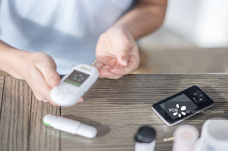 在家使用血糖仪检测血糖以管理糖尿病图片素材