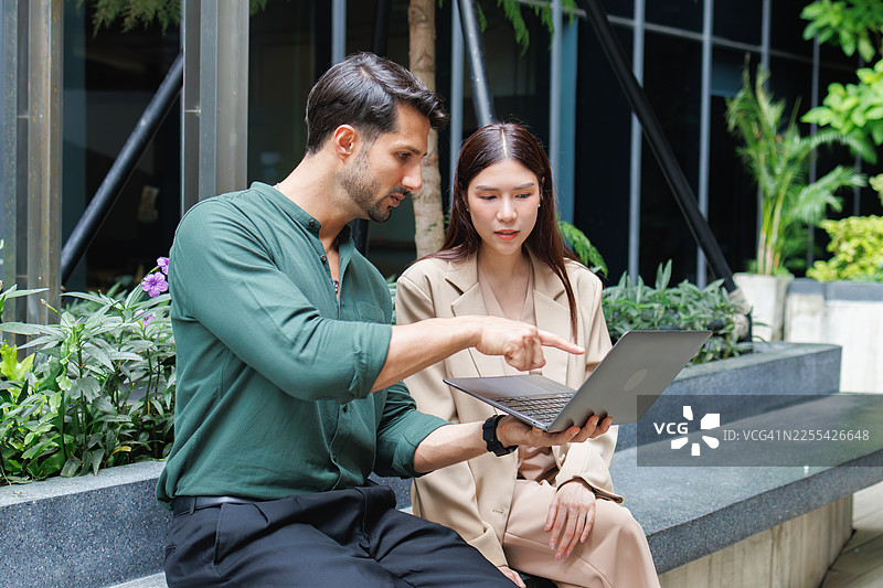 商务同事在办公楼附近户外协作，共同规划商业策略并做出决策。图片素材