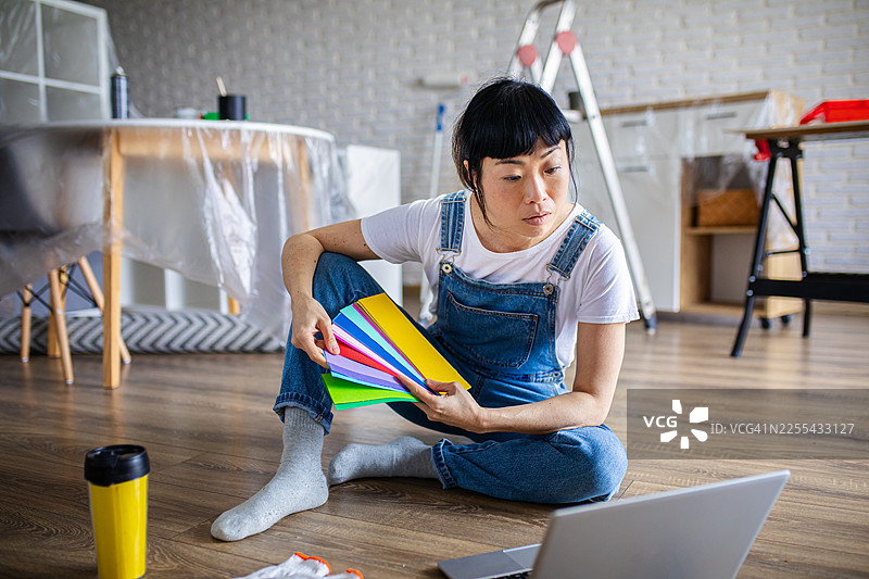 女房主在用笔记本电脑时比较油漆颜色图片素材