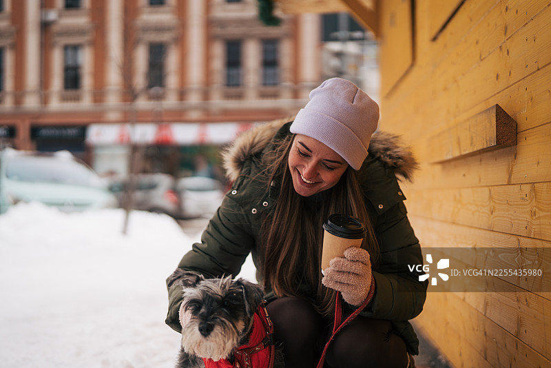 冬天，一位女士和她的狗狗一起享受咖啡时光图片素材
