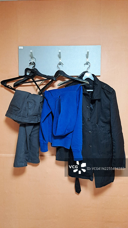 家居收纳概念：桃色墙上的夹克和衣架图片素材