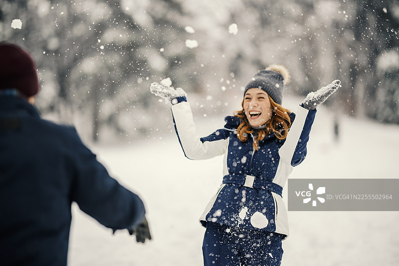 年轻女子在冬天享受嬉戏打雪仗的乐趣图片素材