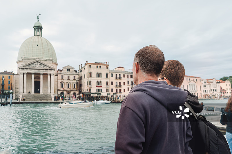 父亲和儿子在威尼斯，意大利，眺望大运河交通和圣母玛利亚健康圣殿图片素材