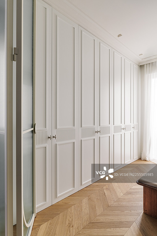 白色嵌入式衣柜搭配木质地板图片素材
