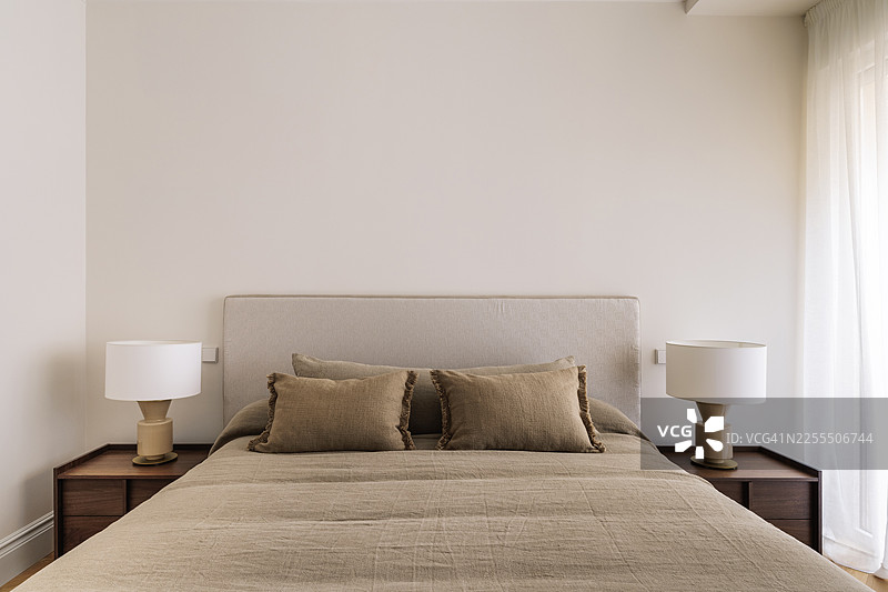 对称的卧室内部，配有床头灯图片素材