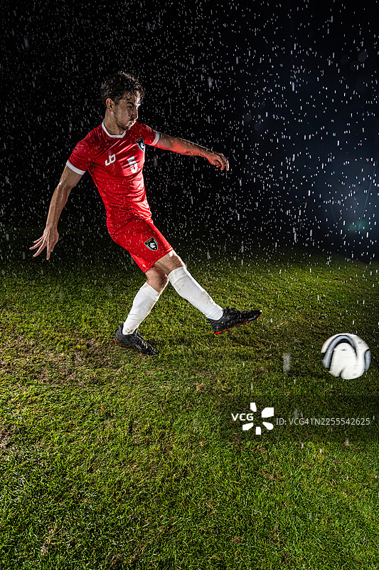 身穿红色队服的足球运动员正在训练图片素材