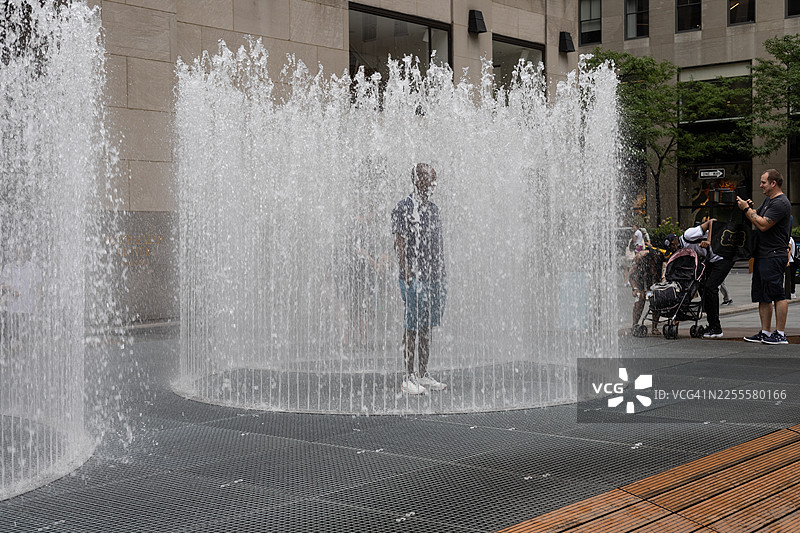 游客在洛克菲勒中心与延佩·海因的“变化空间”喷泉互动图片素材