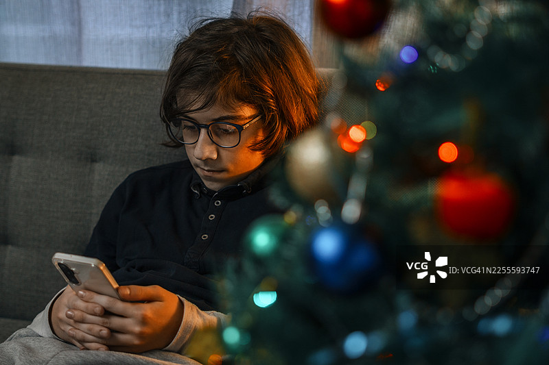 新年第一天，一个青少年独自玩手机，感到孤独图片素材