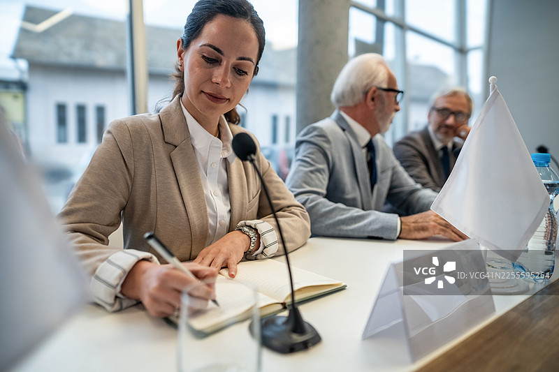 一位女士在政治会议上做笔记图片素材