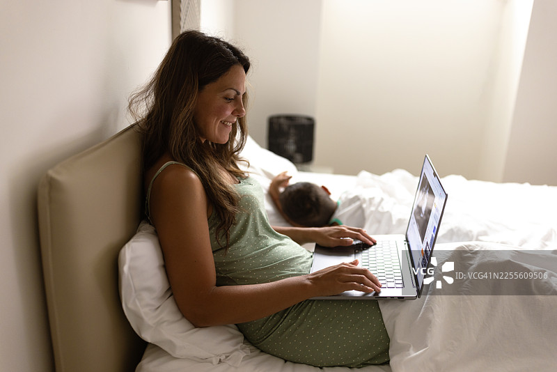 放松地在床上工作的女人图片素材