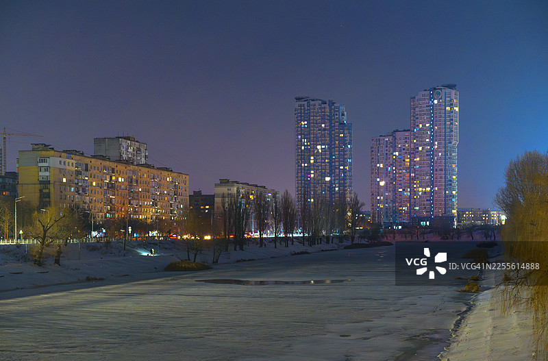 夜晚，基辅市天际线沿着冰封的河流延伸图片素材