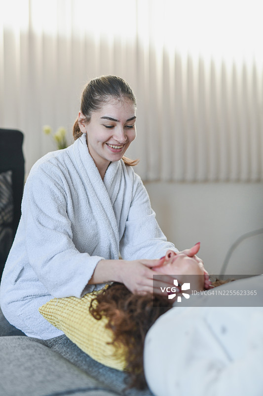 两位女士共享面部按摩，享受舒适的放松水疗日图片素材