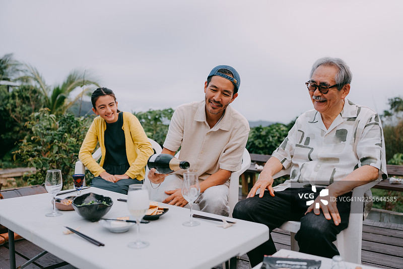 三代同堂的快乐家庭在后院享用开胃酒图片素材