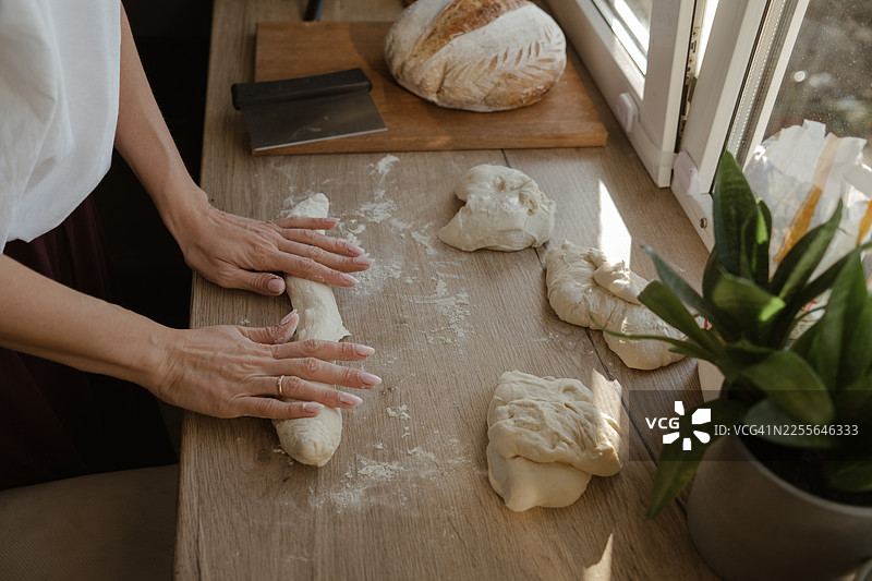一位女士在家烘烤面包，正在揉面团。图片素材