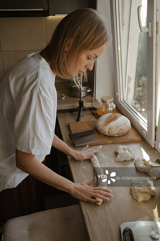 一位女士在家做面包，揉着面团图片素材