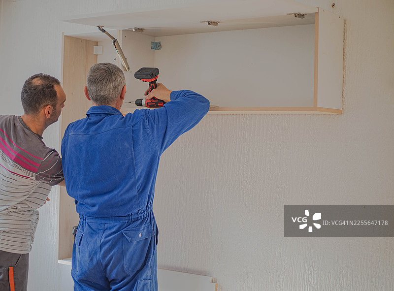 在公寓里摆放家具，木匠们正在组装架子图片素材