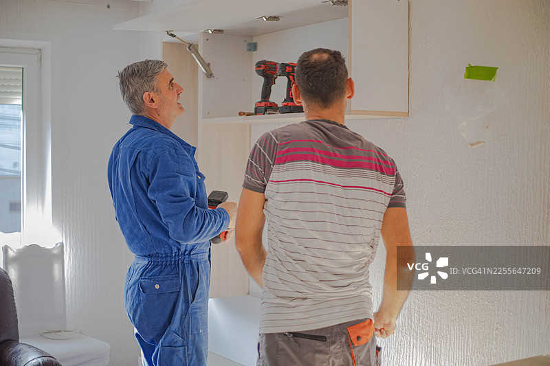 在公寓里放置家具，木匠们在组装架子图片素材