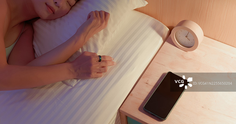 身着智能戒指的亚洲女性在家睡觉图片素材
