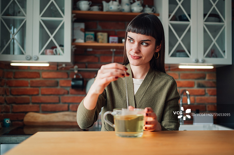 女人在厨房冲泡茶包图片素材