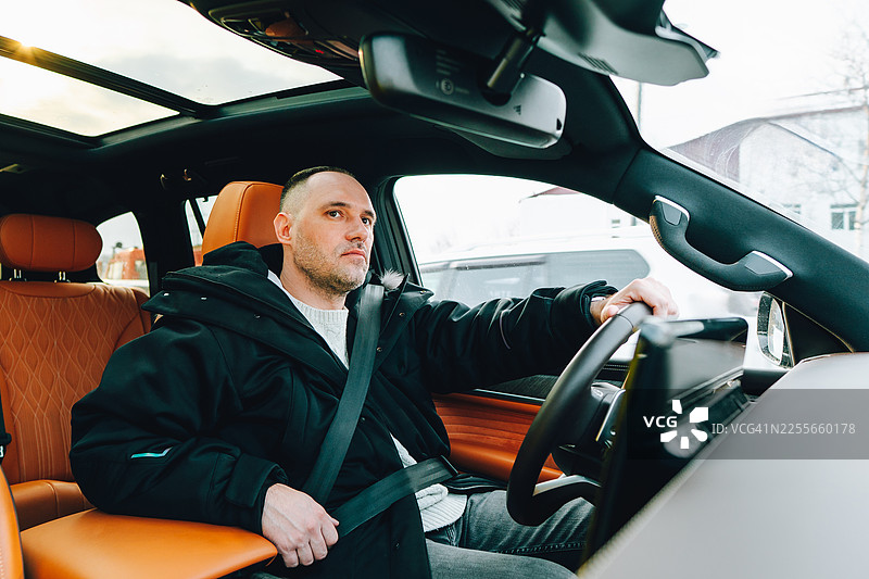 冬天，男人在公路上驾驶豪华SUV，踏上旅程图片素材