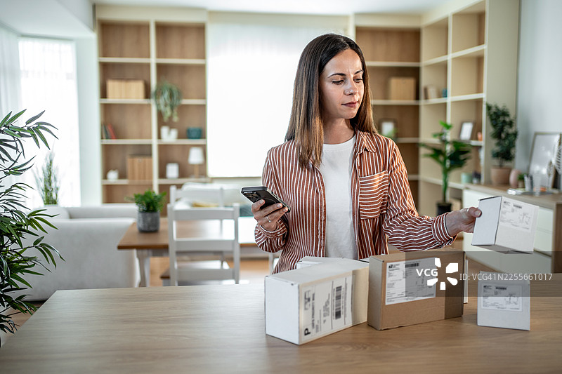 女性为电子商务小企业扫描运输标签图片素材