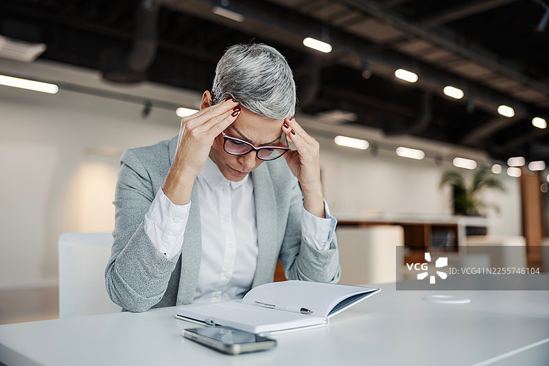 压力大、头痛的女商人在工作图片素材
