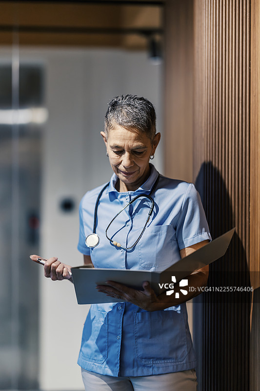 经验丰富的成年护士在医院查阅病人档案图片素材