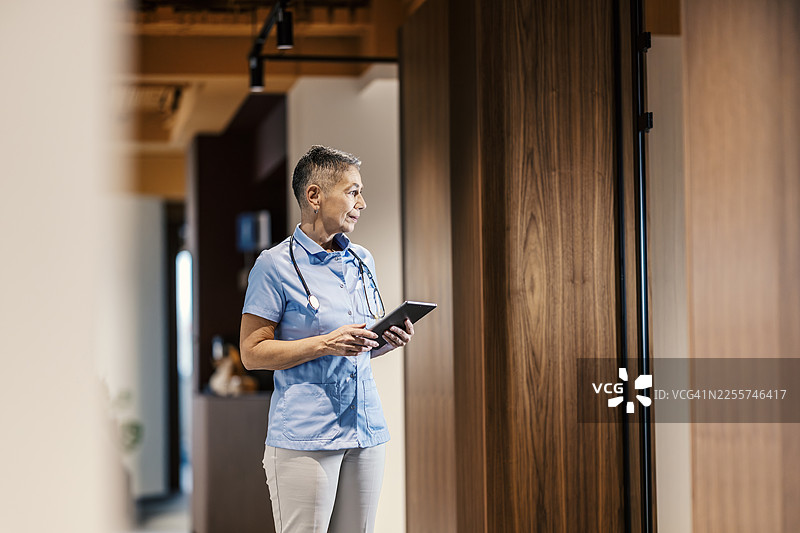 经验丰富的医疗专业人员在诊所使用数字平板电脑图片素材