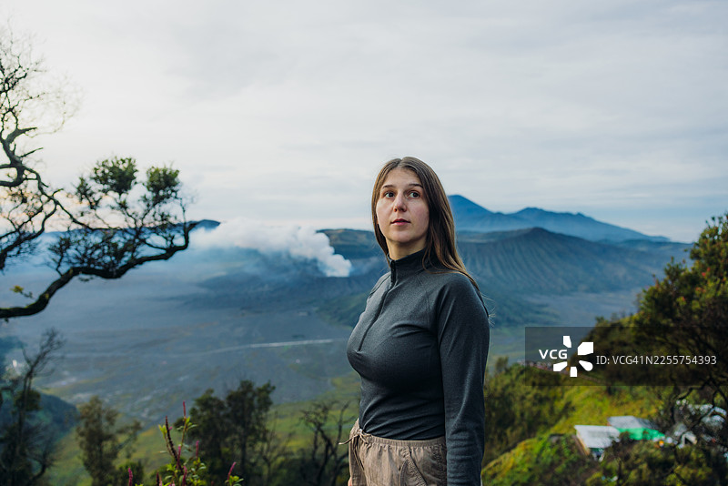 日出时分，印尼布罗莫塞梅鲁火山壮丽景色前，一位宁静的女子正在欣赏图片素材