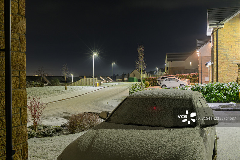 住宅区车道上被冰雪覆盖的汽车图片素材