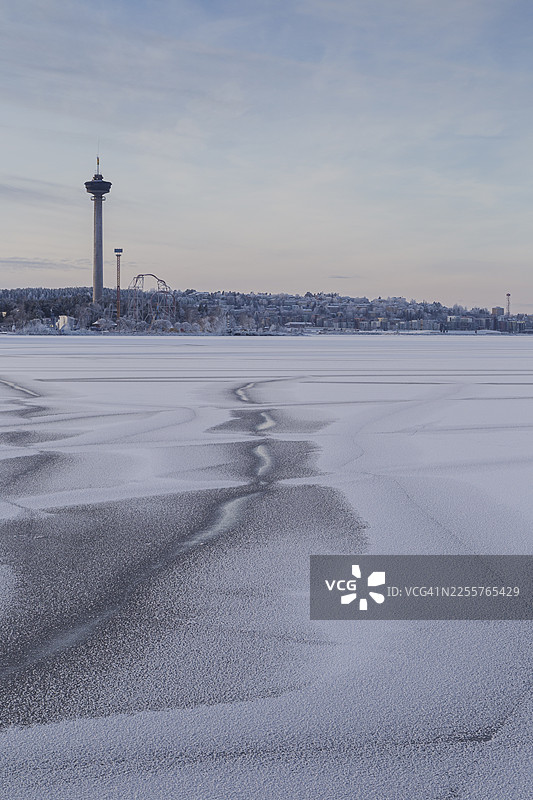 冬季白天,从芬兰结冰积雪的纳西湖(Lake Näsijärvi)眺望纳辛内拉观景塔(Näsinneula observation tower)、萨坎涅米游乐园(Särkänniemi amusement park)和皮斯帕拉(Pispala)。图片素材