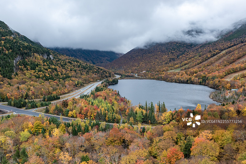艺术家悬崖瞭望台和回声湖景观 - 秋季色彩斑斓的山林公路景色，新罕布什尔州林肯，美国图片素材